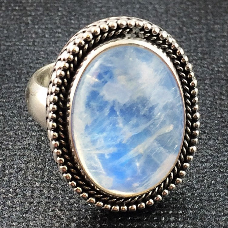 Giant blue moonstone ring. Got this for 20 bucks. It was in rough shape,  silver was tarnished and the cab was completely opaque. I polished down the  cab, and dabbed on some